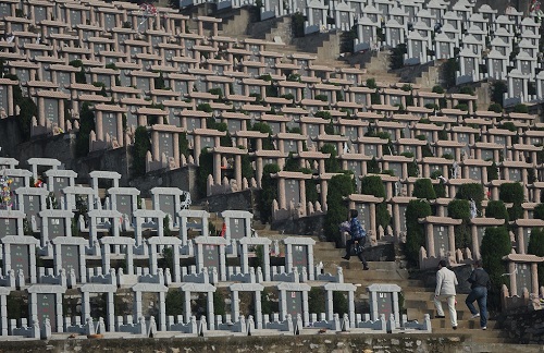 Chinese families arrive at a cemetary for "Qingming" in Hefei, east China's Anhui province on April 3, 2012. "Qingming", also known as "grave-sweeping day" or All Souls Day, and to mark the day, Chinese traditionally tend the graves of their departed loved ones and often burn paper money, model houses, cars, mobile phones and other goods as offerings to honour them and keep them comfortable in the afterlife. CHINA OUT AFP PHOTO (Photo credit should read STR/AFP/Getty Images)